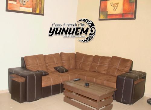 a brown leather couch and a table in a room at Casa & Beach Club Yunuem in Bacalar