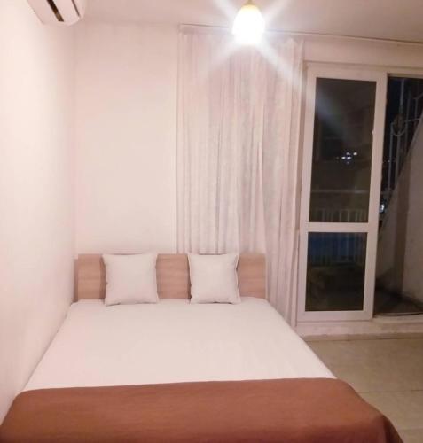 een bed met 2 kussens in een kamer met een raam bij STUDIO- The SEA in Varna