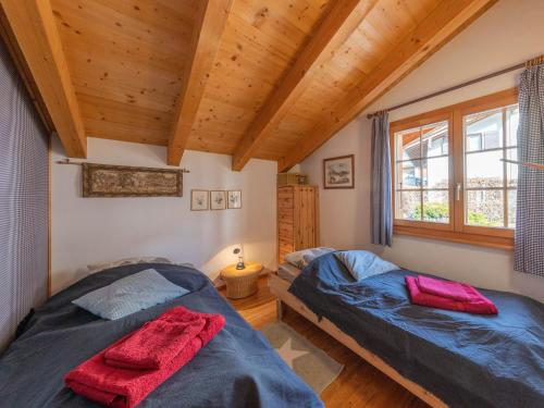 two beds in a room with wooden ceilings at Chalet L'échappée belle in Verbier