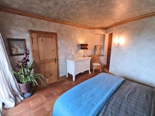 Schlafzimmer mit einem blauen Bett und einem Schreibtisch in der Unterkunft Beautiful apartment over the mountain in Crans-Montana