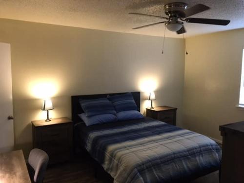 a bedroom with a blue bed with two lights on it at Simple 1-bedroom unit upstairs close to Fort Sill! in Lawton