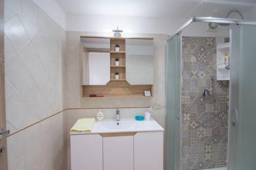 een badkamer met een witte wastafel en een douche bij Ncantu home in Palermo