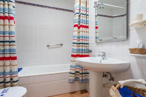 ein Badezimmer mit einem Waschbecken, einer Badewanne und einem WC in der Unterkunft El Sombrerito 5 in Caleta de Sebo