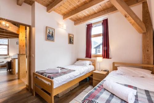 2 bedden in een kamer met houten plafonds bij Apartment Vila 2 Chamonix in Chamonix-Mont-Blanc