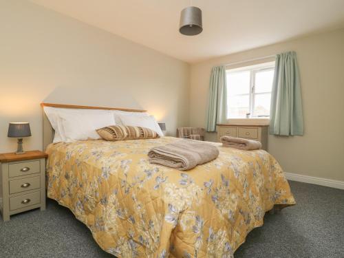 a bedroom with a large bed and a window at Armstrong Cottage in Beverley