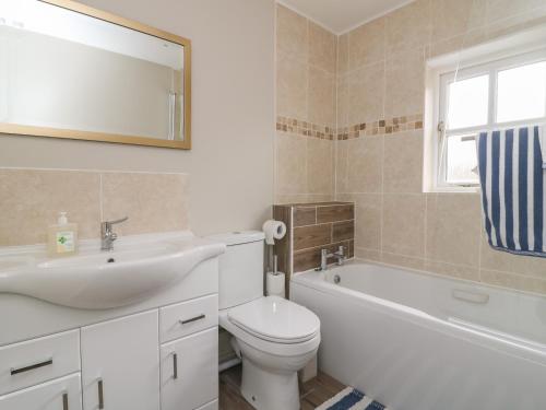 une salle de bain avec un lavabo, des toilettes et une baignoire dans l'établissement Armstrong Cottage, à Beverley