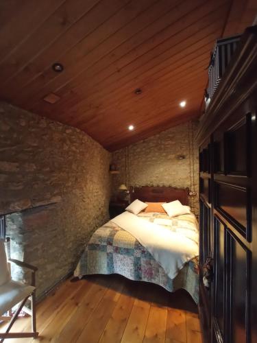 a bedroom with a bed in a stone wall at El Paller Urús Cerdanya in Urus