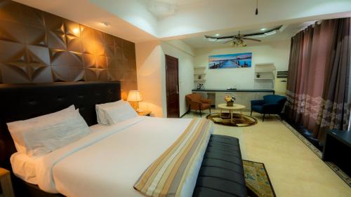 فندق لانتانا في دار السلام: غرفة نوم مع سرير وغرفة معيشة