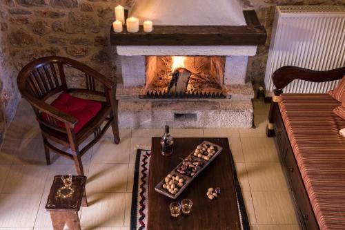 a living room with a fireplace and a table and a chair at Agroktima in Leonidion