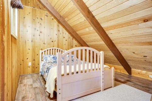 a bedroom with a crib in a wooden ceiling at The Chalet on Lopez in Islandale