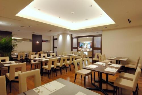 a dining room with tables and chairs in a restaurant at Rembrandt Hotel Atsugi in Atsugi