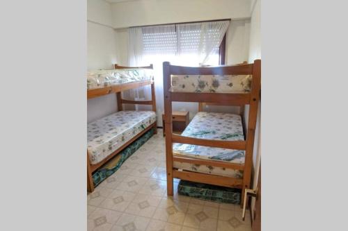 two bunk beds in a room with a window at Excelente departamento vista al mar + 2 cocheras in San Bernardo