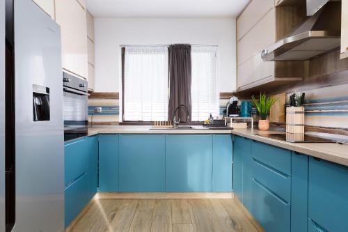 a kitchen with blue cabinets and a sink at Villa Montana in Braşov