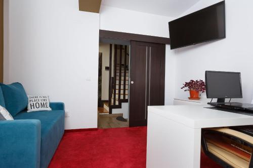 a living room with a blue couch and a tv at Villa Montana in Braşov