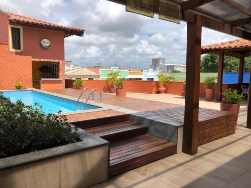 a backyard with a swimming pool and a wooden deck at Alagoinhas Plaza Hotel in Alagoinhas