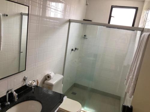 a bathroom with a shower with a toilet and a sink at Alagoinhas Plaza Hotel in Alagoinhas
