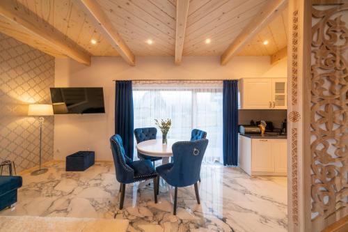 kuchnia i jadalnia ze stołem i krzesłami w obiekcie Luxury Houses & Apartments Zaliński w Zakopanem