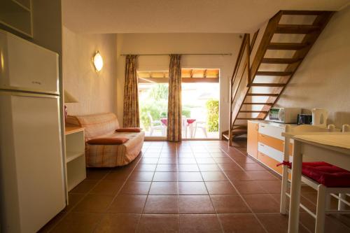 Il comprend une cuisine et un salon avec un réfrigérateur et des escaliers. dans l'établissement Residence de Tourisme Marina Corsa, à Ghisonaccia