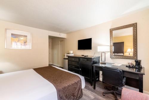 a hotel room with a bed and a desk with a computer at Americas Best Value Inn and Suites Flagstaff in Flagstaff