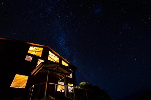 a house at night with the stars in the sky at Hostal Las Natalias in Futaleufú