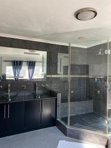 a bathroom with two sinks and a glass shower at wilderness oceanview in Wilderness