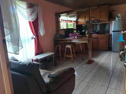 a living room and kitchen with a couch and a table at Rancho de Lelo Ecolodge in Monteverde Costa Rica