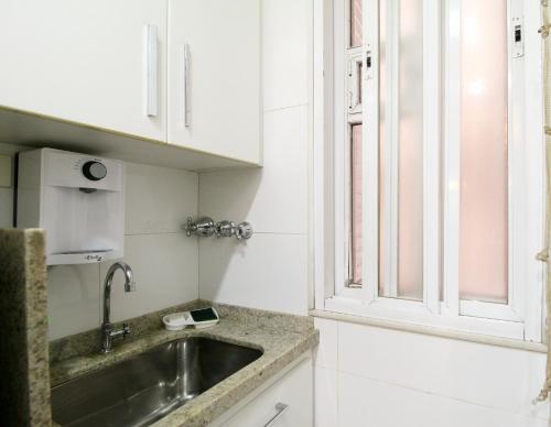 cocina con fregadero y ventana en Studio Top Ipanema, en Río de Janeiro