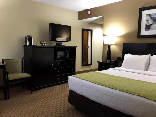 a hotel room with a bed and a flat screen tv at NavajoLand Hotel in Tuba City