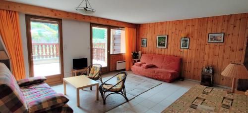 uma sala de estar com um sofá vermelho e cadeiras em Boost Your Immo Les Mouflons Vars 360 em Vars