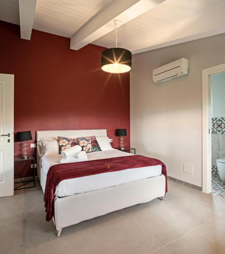 a bedroom with a bed and a red wall at Podere GIUSTI in Reggello