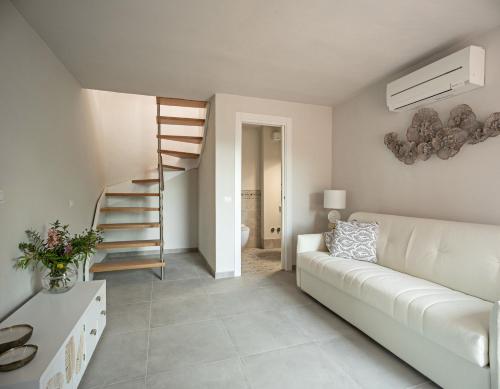 a living room with a white couch and a staircase at Podere GIUSTI in Reggello