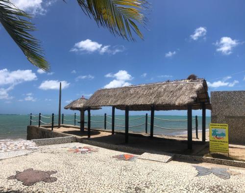 a pavilion on the beach with the ocean at Village Galés de Maragogi in Maragogi