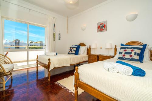 1 Schlafzimmer mit 2 Betten und einem großen Fenster in der Unterkunft Sunny Seaside Escape in Lagos