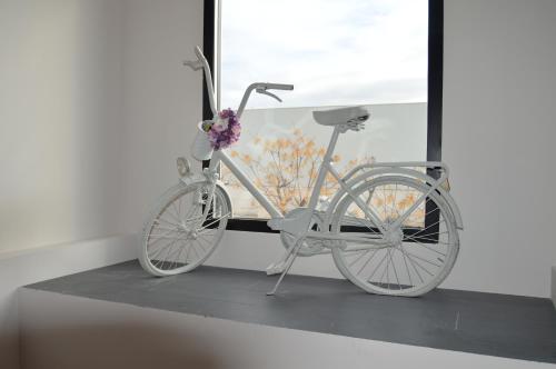 ein weißes Fahrrad, das neben einem Fenster parkt in der Unterkunft Hotel Ibi in Ibi