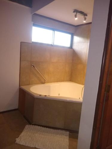 a bath tub in a bathroom with a window at Willy's Country Club Cauquenes in De Cauquenes