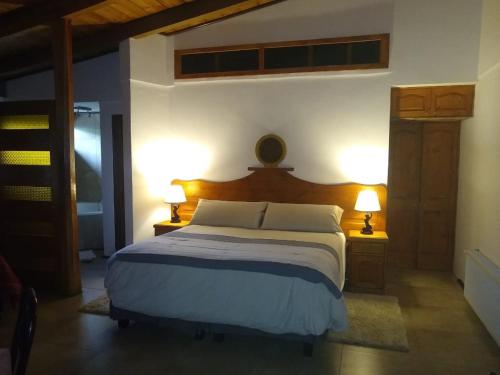 a bedroom with a large bed with two lamps at Willy's Country Club Cauquenes in De Cauquenes