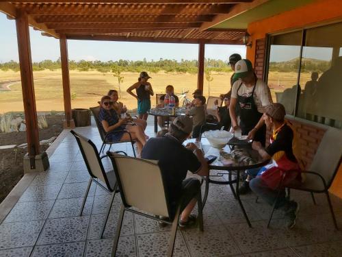 a group of people sitting at tables on a porch at Willy's Country Club Cauquenes in De Cauquenes