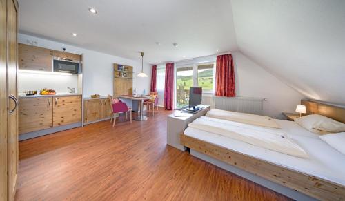 a bedroom with a large bed and a kitchen at Hotel Zum Löwen - Unteres Wirtshaus in Titisee-Neustadt