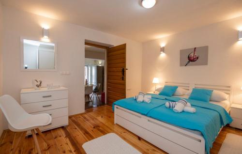 a bedroom with a blue bed and a sink at Apartman Genova Imotski in Donji Vinjani