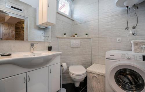 a bathroom with a sink and a washing machine at Apartman Genova Imotski in Donji Vinjani