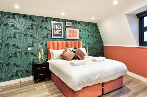 a bedroom with a bed with a green wall at Your Apartment I Clifton Village in Bristol