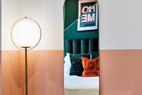 a floor lamp with a mirror next to a bed at Your Apartment I Clifton Village in Bristol