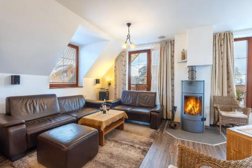 a living room with a couch and a fireplace at Family Apartments Hotel Kukučka - Tatranská Lomnica in Vysoke Tatry - Tatranska Lomnica.