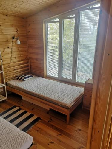 a room with a bed and a window in a wooden room at Savas Uostas in Šventoji