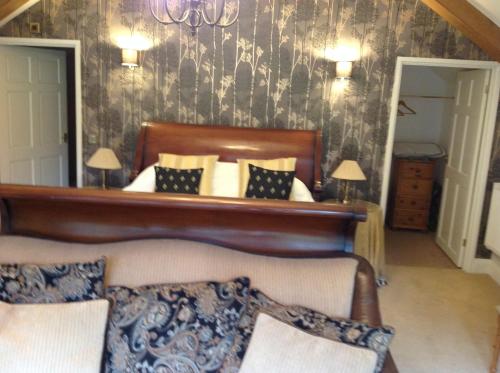a bedroom with a bed with a wooden head board at Felbrigg Lodge Bed And Breakfast in Aylmerton