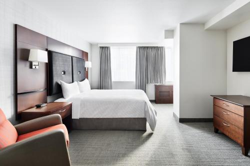 ein Hotelzimmer mit einem Bett und einem TV in der Unterkunft Club Quarters Hotel Embarcadero, San Francisco in San Francisco