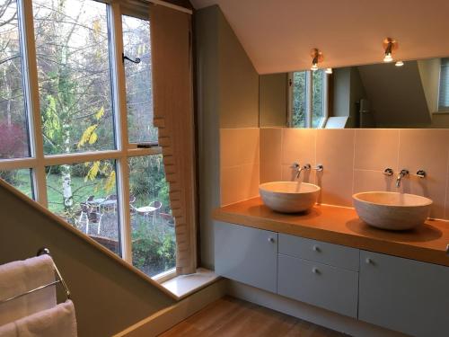 two sinks in a bathroom with a large window at Felbrigg Lodge Bed And Breakfast in Aylmerton