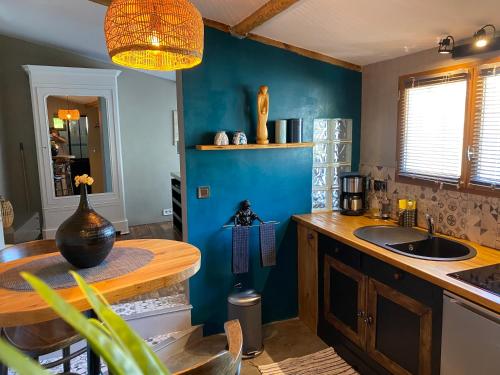 - une cuisine avec un évier et un mur bleu dans l'établissement Le Maskalou, à La Colle-sur-Loup