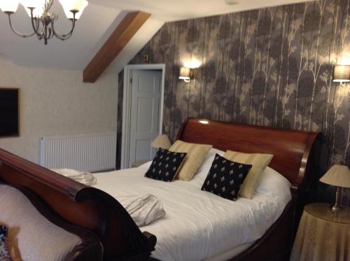 a bedroom with a large bed with white sheets and pillows at Felbrigg Lodge Bed And Breakfast in Aylmerton