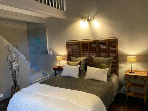 a bedroom with a large bed with white pillows at Le Maskalou in La Colle-sur-Loup